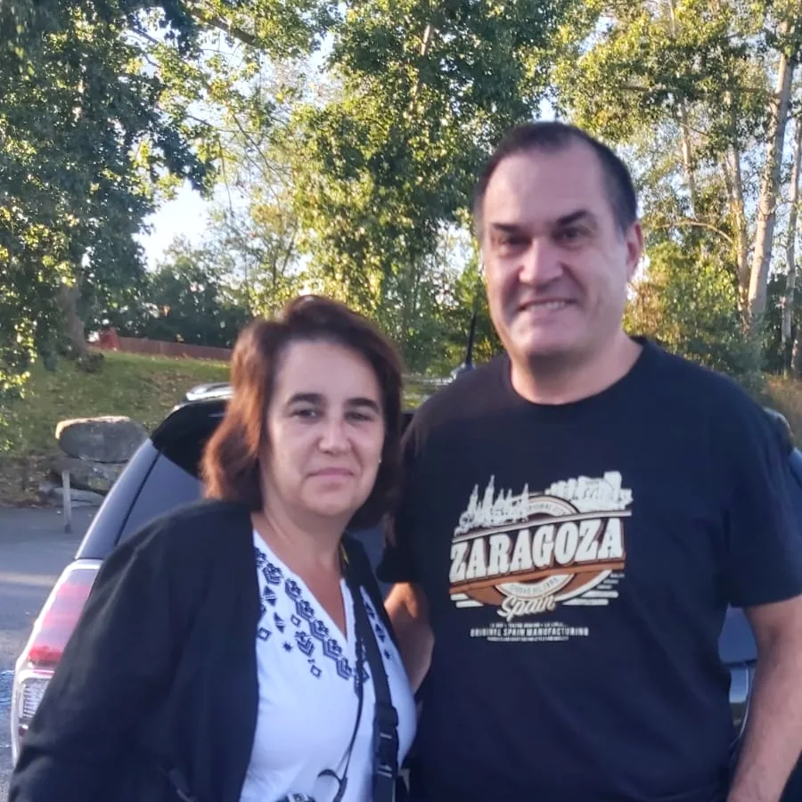 Deux de nos clients debout à côté de la voiture.