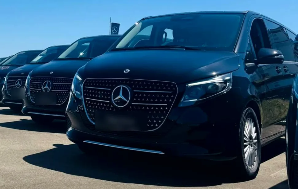 Une rangée de vans Mercedes Classe V noirs garés côte à côte.